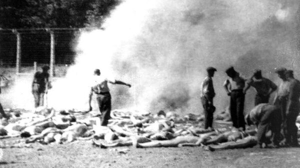 Члены зондеркоманды сжигают тела убитых газом заключенных Освенцима